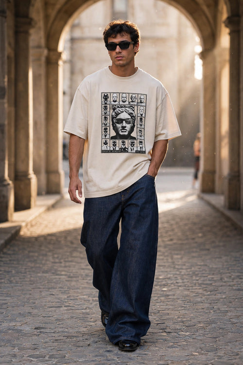 Man wearing cream Archive Muse Tee with black portrait print in stone archway